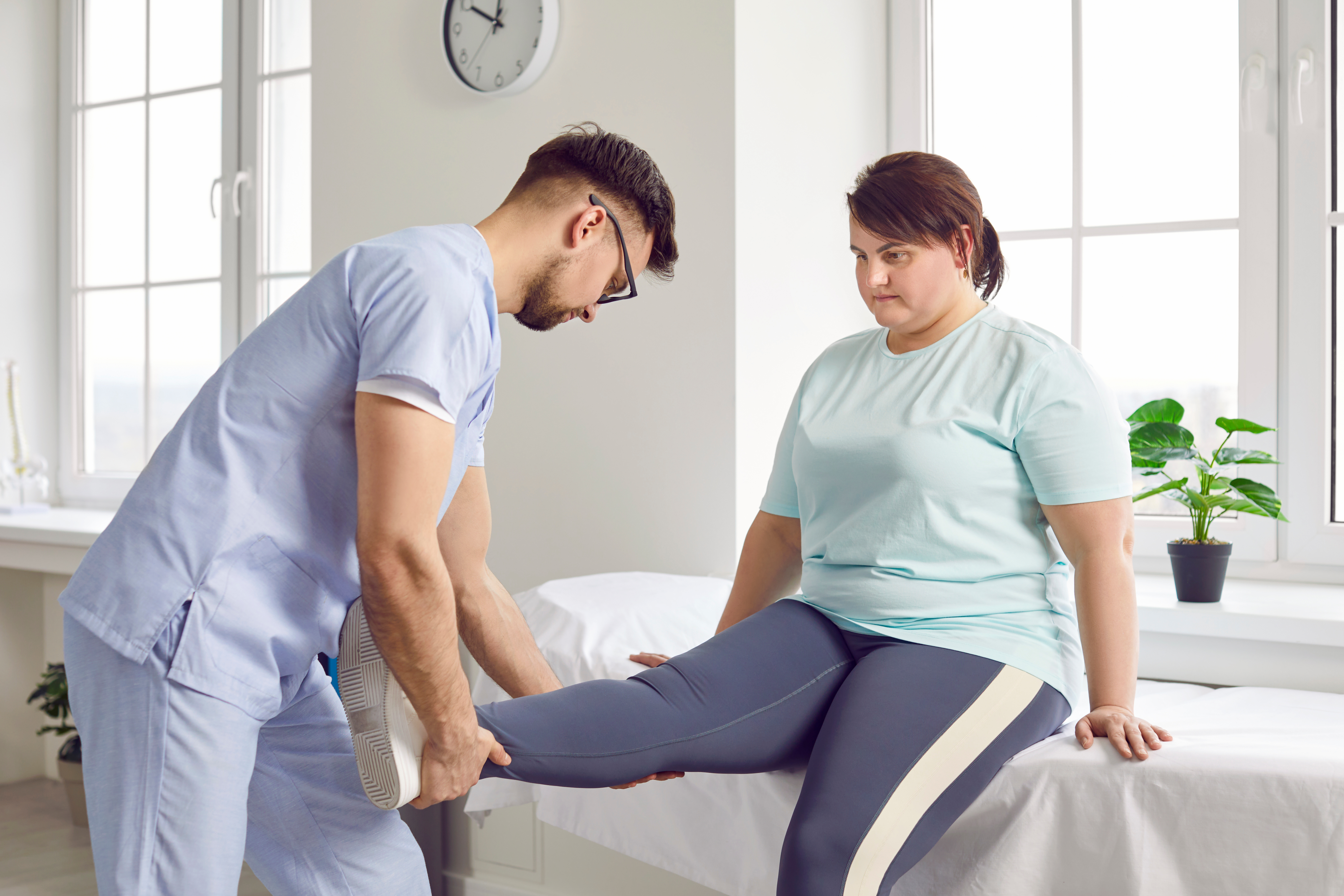 Physiotherapist examines overweight female patient
